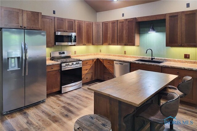 1673 Evan Dr, Defiance, OH 43512 - kitchen with appliances with stainless steel finishes, a sink, light wood-style floors, light countertops, and a breakfast bar area