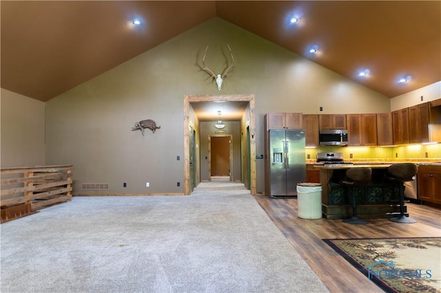 1673 Evan Dr, Defiance, OH 43512 - kitchen featuring stainless steel appliances, high vaulted ceiling, a center island, a breakfast bar area, and light countertops