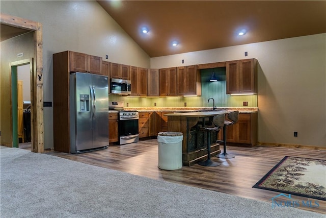 1673 Evan Dr, Defiance, OH 43512 - kitchen with stainless steel appliances, a kitchen island, a breakfast bar area, a sink, and light countertops