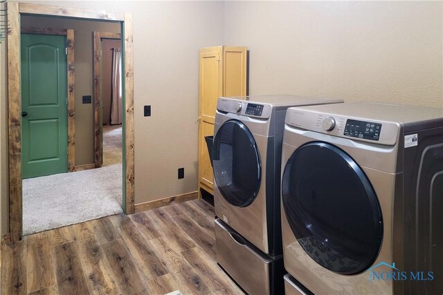 1673 Evan Dr, Defiance, OH 43512 - laundry room featuring washer and dryer, wood finished floors, and cabinet space