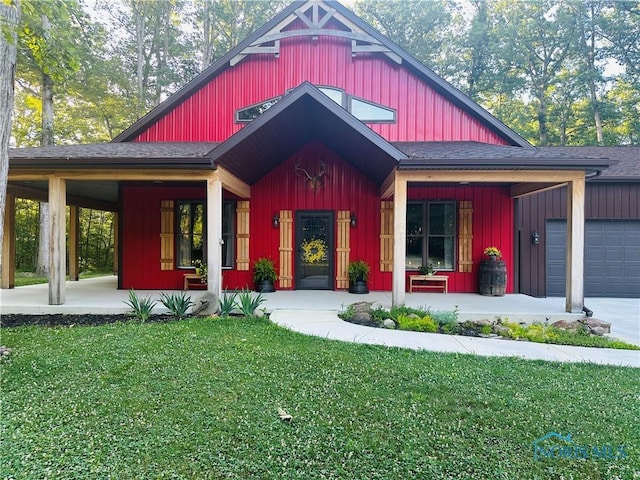1673 Evan Dr, Defiance, OH 43512 - view of front of home with board and batten siding, covered porch, a front lawn, and an attached garage