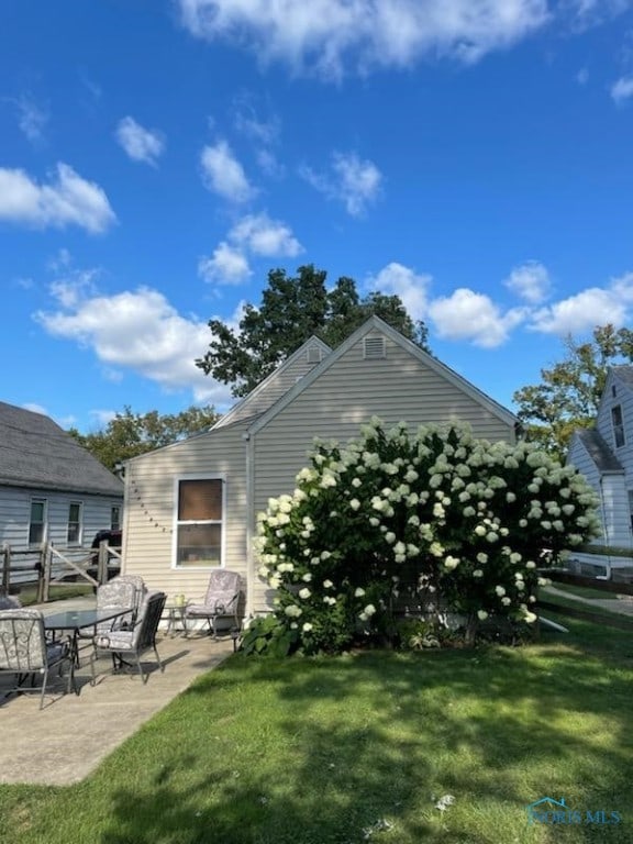 rear view of house with a lawn and a patio area