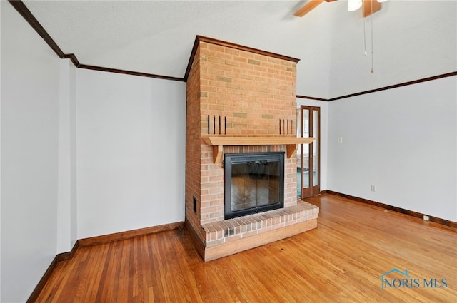 1000 Washington Ave, Findlay, OH 45840 - unfurnished living room with crown molding, a brick fireplace, wood finished floors, a ceiling fan, and baseboards