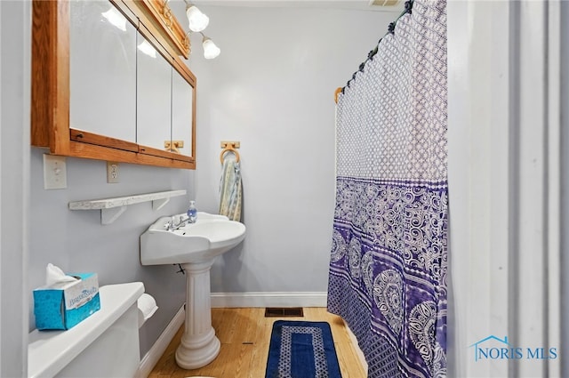 1000 Washington Ave, Findlay, OH 45840 - full bathroom with toilet, wood finished floors, baseboards, and curtained shower