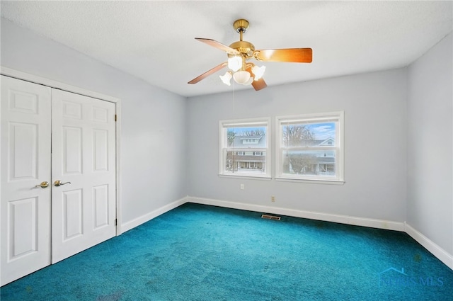 1000 Washington Ave, Findlay, OH 45840 - unfurnished bedroom featuring dark carpet, baseboards, a closet, and ceiling fan