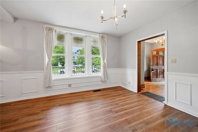 1000 Washington Ave, Findlay, OH 45840 - spare room featuring a chandelier, a wainscoted wall, and wood finished floors
