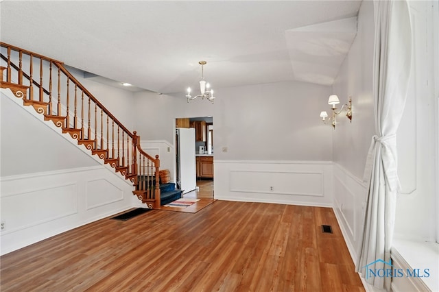 1000 Washington Ave, Findlay, OH 45840 - entrance foyer with a chandelier, light wood-type flooring, stairway, a wainscoted wall, and a decorative wall