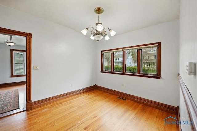 1000 Washington Ave, Findlay, OH 45840 - unfurnished room with healthy amount of natural light, a chandelier, baseboards, and light wood finished floors