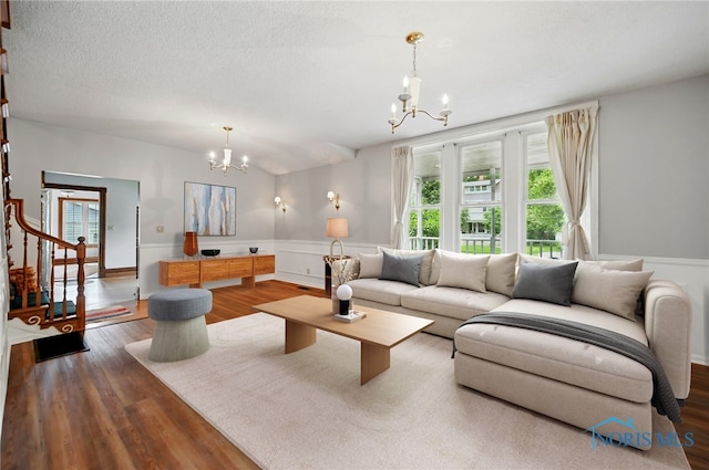 1000 Washington Ave, Findlay, OH 45840 - living room featuring a chandelier, a wainscoted wall, wood finished floors, and a textured ceiling