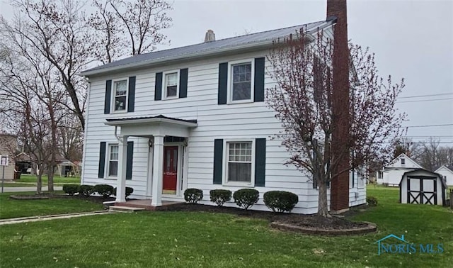 740 E Main St, Ottawa, OH 45875 - colonial inspired home with a chimney, metal roof, a shed, and a front yard