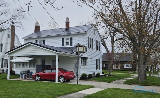 740 E Main St, Ottawa, OH 45875 - view of front of house featuring a standing seam roof, a chimney, a front yard, and metal roof