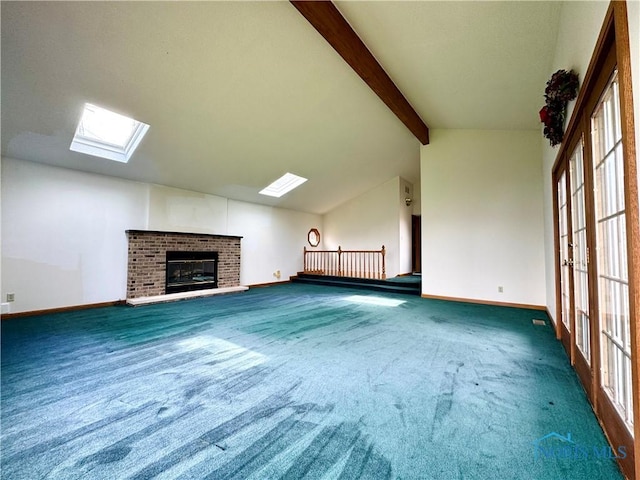 1965 Colwell Cir, Defiance, OH 43512 - unfurnished living room featuring baseboards, vaulted ceiling with skylight, a brick fireplace, and carpet