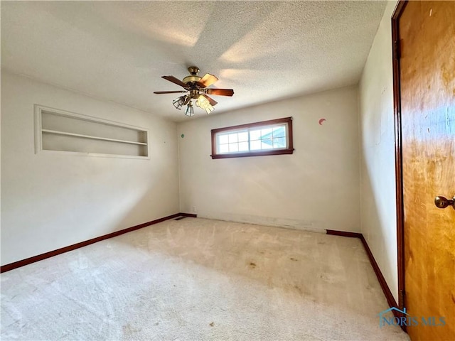1965 Colwell Cir, Defiance, OH 43512 - spare room with a textured ceiling, a ceiling fan, baseboards, and light carpet