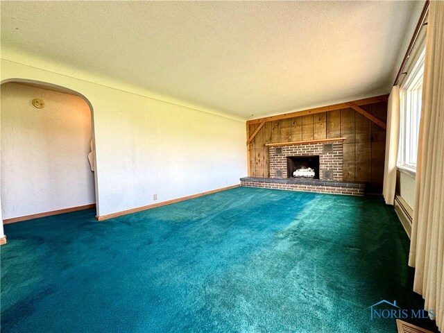 1965 Colwell Cir, Defiance, OH 43512 - unfurnished living room with a baseboard heating unit, a fireplace, carpet flooring, and a textured ceiling