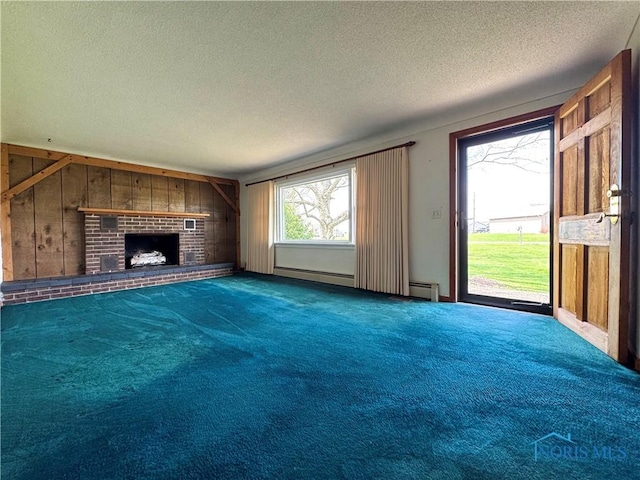 1965 Colwell Cir, Defiance, OH 43512 - unfurnished living room with a textured ceiling, wood walls, a baseboard heating unit, a brick fireplace, and carpet flooring