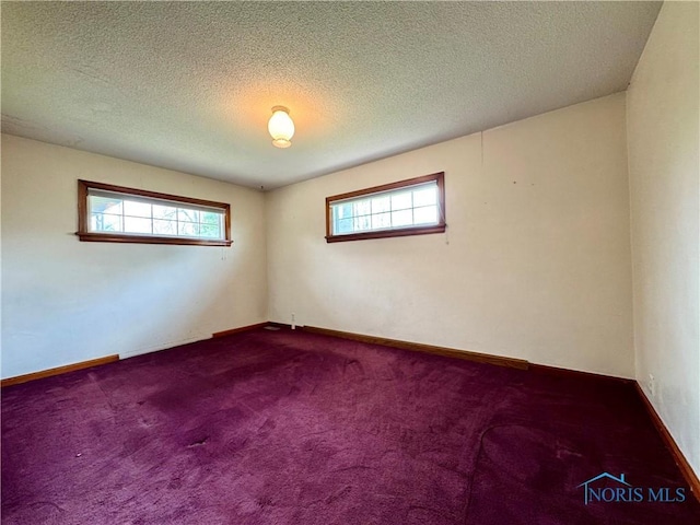 1965 Colwell Cir, Defiance, OH 43512 - spare room with dark colored carpet, baseboards, and a textured ceiling
