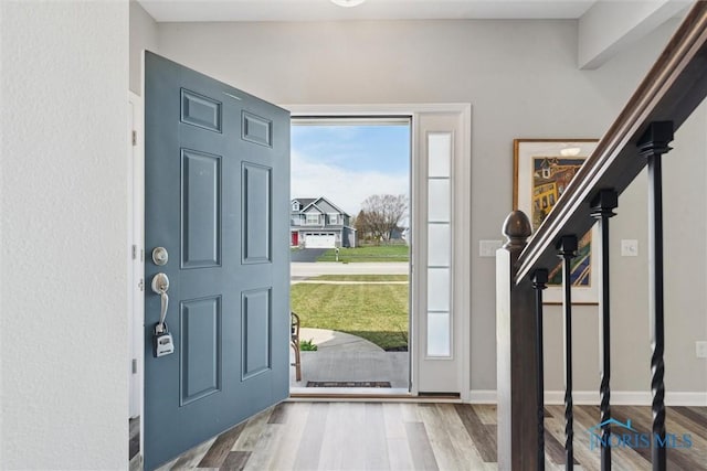 foyer entrance with baseboards and wood finished floors