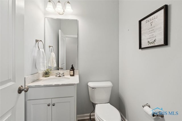 half bathroom with vanity and toilet