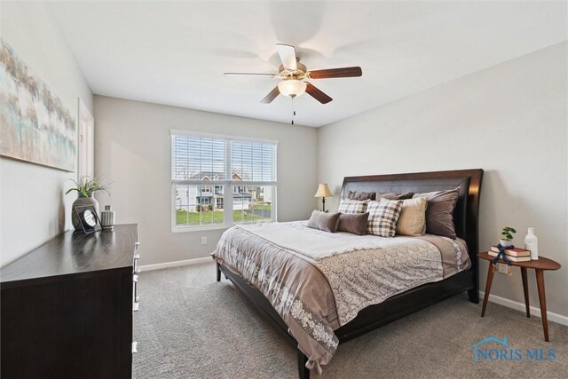 carpeted bedroom with a ceiling fan and baseboards
