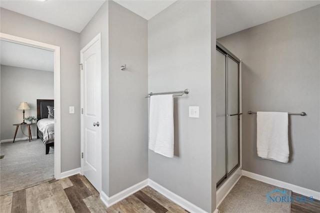 full bath with baseboards, ensuite bathroom, wood finished floors, and a stall shower