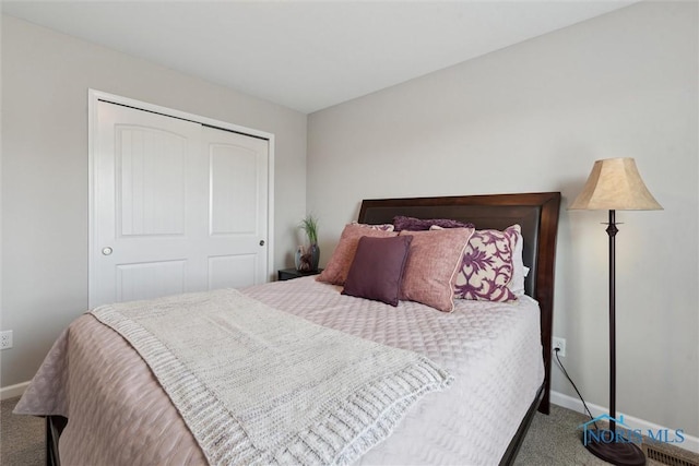 carpeted bedroom with a closet and baseboards