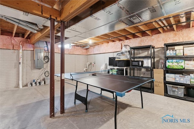 rec room with concrete floors and electric panel