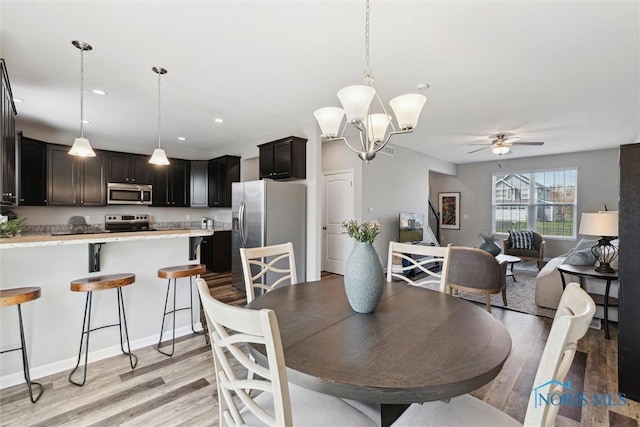 dining area featuring recessed lighting, ceiling fan with notable chandelier, and light wood-type flooring