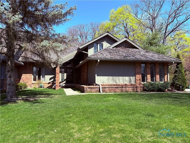 view of front of property featuring brick siding and a front yard