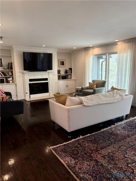 living room featuring a fireplace, recessed lighting, and dark wood finished floors