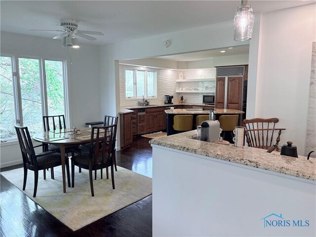 dining area with a healthy amount of sunlight and dark wood-type flooring