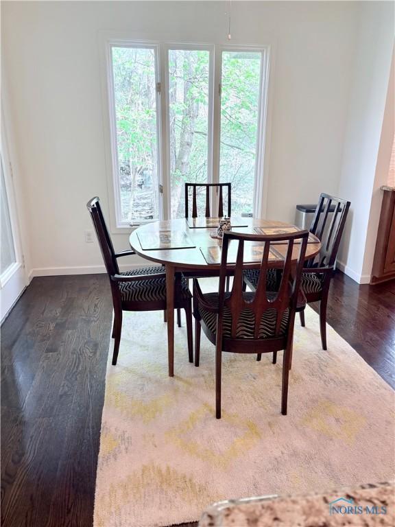 dining area featuring dark wood-style floors and baseboards