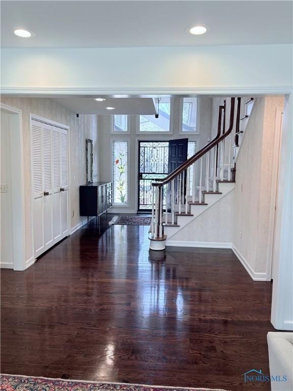 entryway with wood finished floors, stairs, and baseboards