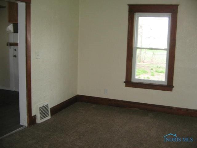 unfurnished room with carpet floors, visible vents, baseboards, and a healthy amount of sunlight