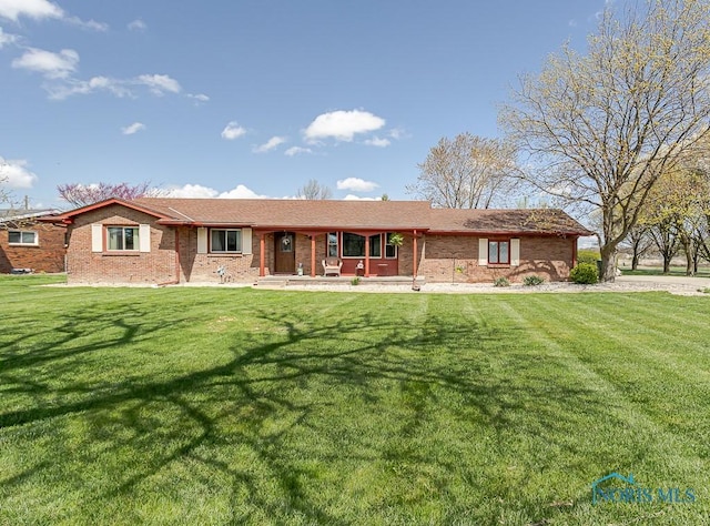 ranch-style house with a front lawn, brick siding, and a porch