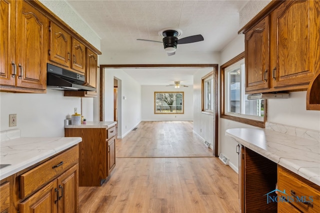 1314 Stoner Rd, Fostoria, OH 44830 - kitchen with ceiling fan, brown cabinets, and under cabinet range hood