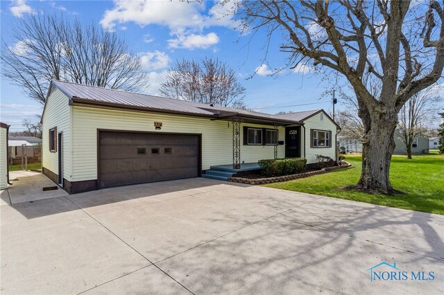 1314 Stoner Rd, Fostoria, OH 44830 - single story home featuring a garage, concrete driveway, a front yard, and metal roof