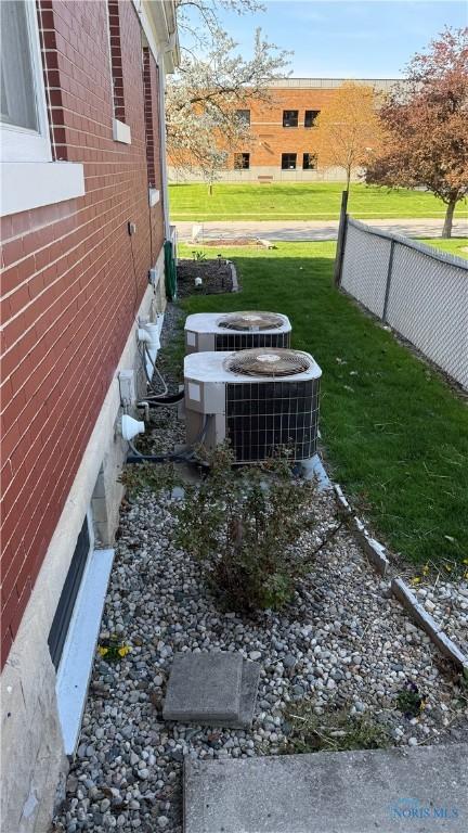 view of yard with central air condition unit and fence