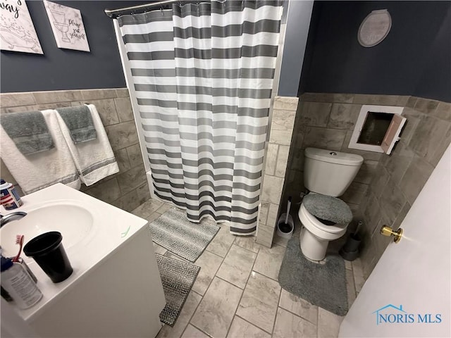 3250 Otto St, Toledo, OH 43608 - full bathroom featuring a wainscoted wall, a sink, toilet, tile walls, and curtained shower