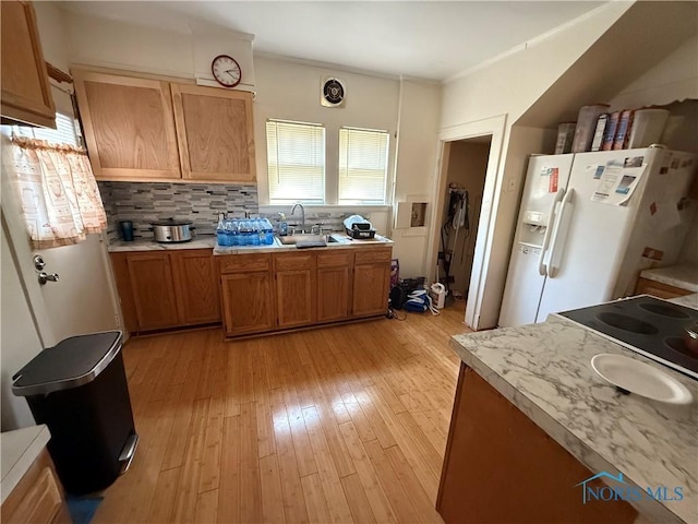3250 Otto St, Toledo, OH 43608 - kitchen with white refrigerator with ice dispenser, light countertops, a sink, and light wood-style flooring