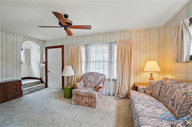 806 W Tiffin St, Fostoria, OH 44830 - carpeted living area with arched walkways, wood walls, and a ceiling fan
