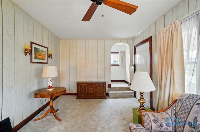 806 W Tiffin St, Fostoria, OH 44830 - living area with carpet floors, wood walls, arched walkways, and ceiling fan