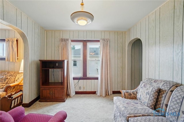806 W Tiffin St, Fostoria, OH 44830 - sitting room featuring carpet, wooden walls, arched walkways, and plenty of natural light