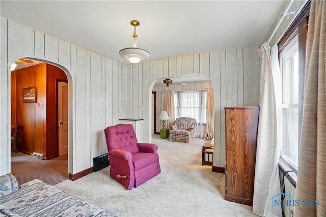 806 W Tiffin St, Fostoria, OH 44830 - living area featuring wood walls, carpet, visible vents, and arched walkways