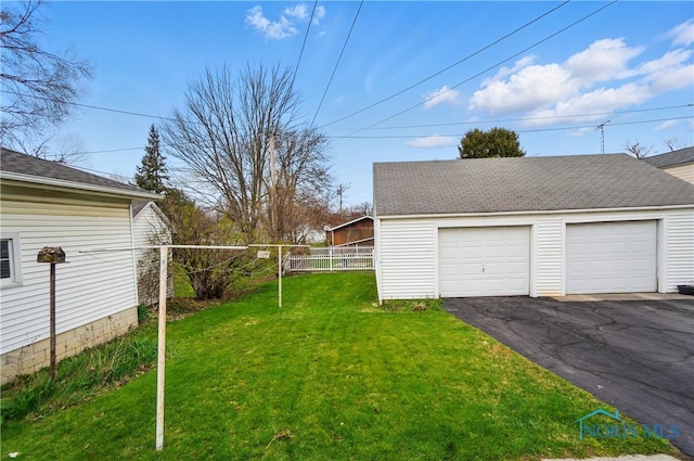 806 W Tiffin St, Fostoria, OH 44830 - view of yard featuring fence, an outbuilding, and a garage