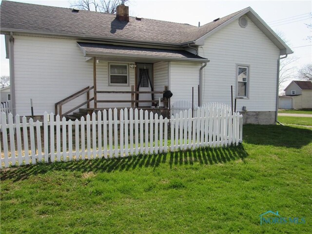 104 S Summit St, Edon, OH 43518 - rear view of house featuring a lawn, a chimney, covered porch, fence, and roof with shingles