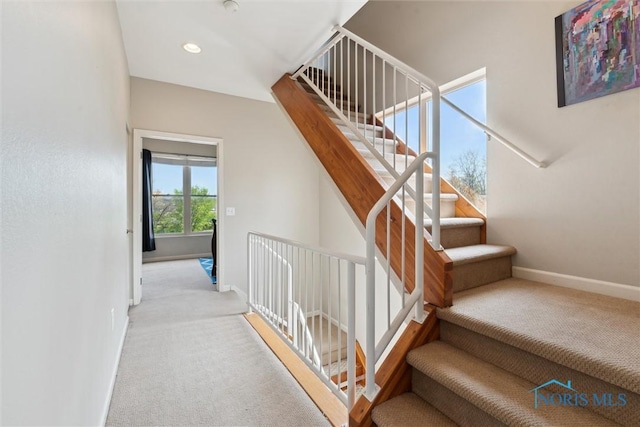 stairway with baseboards and carpet