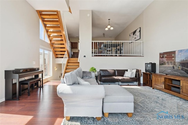 living area with baseboards, stairs, and wood finished floors