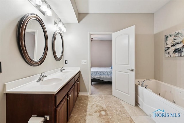 bathroom with a sink, baseboards, a whirlpool tub, and double vanity
