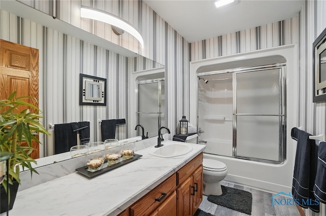 full bath with toilet, vanity, and wallpapered walls