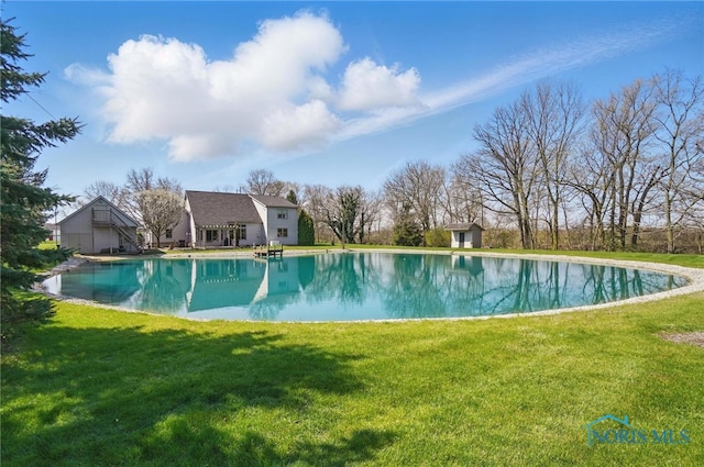 outdoor pool featuring a lawn